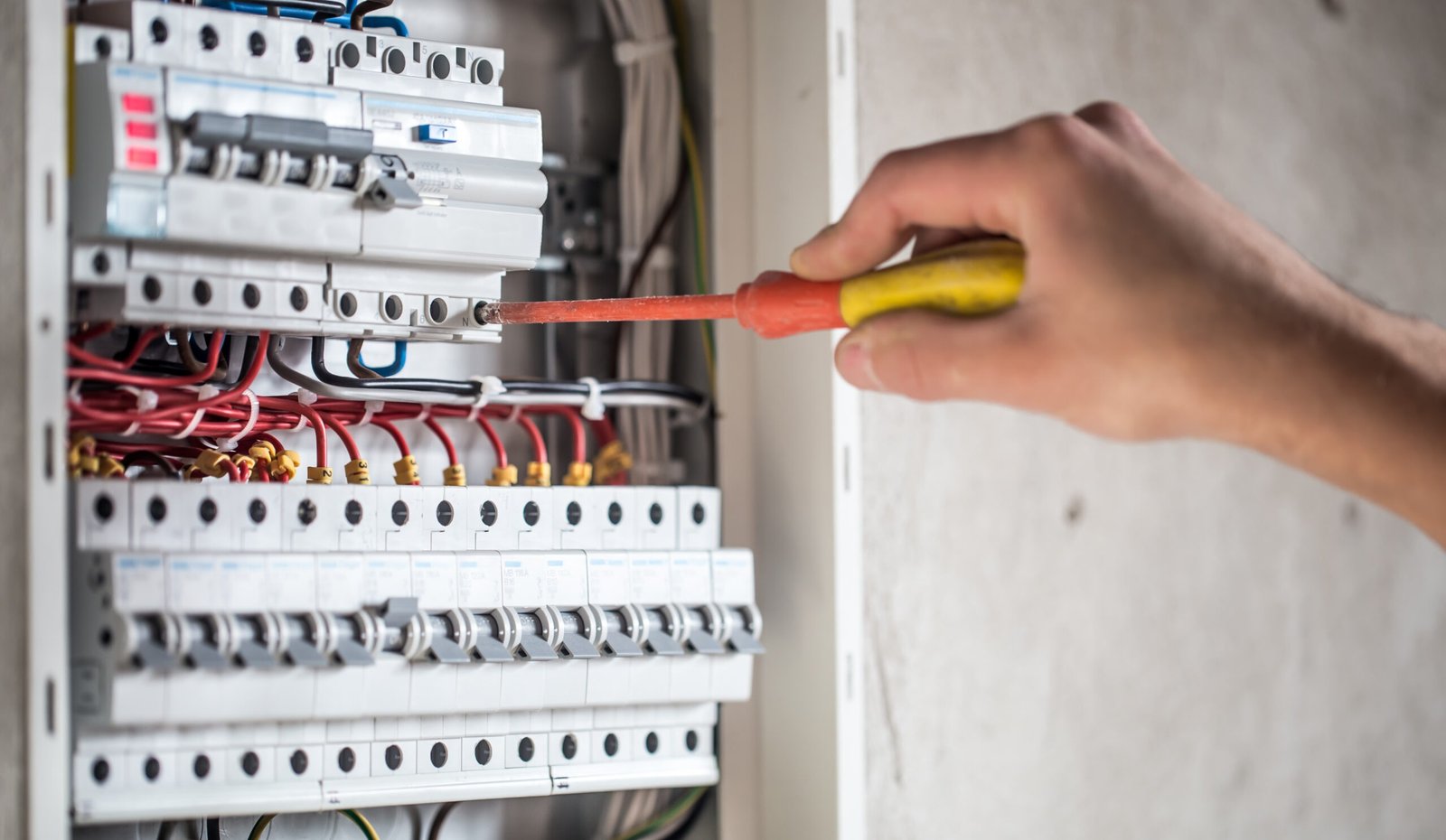 man-electrical-technician-working-switchboard-with-fuses-installation-connection-electrical-equipment